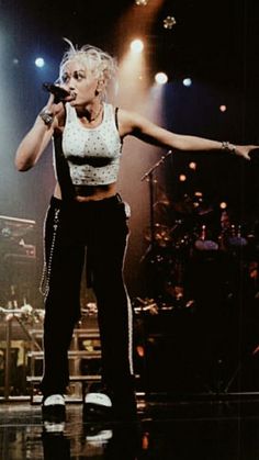 a woman standing on top of a stage holding a microphone