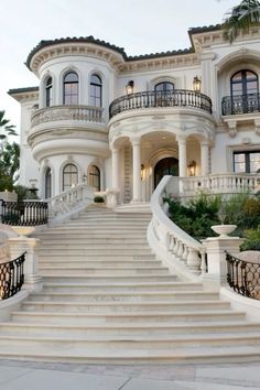 a large white house with stairs leading up to it