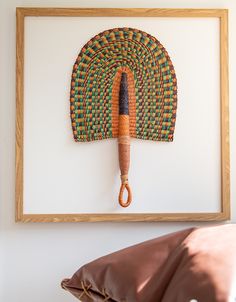 an umbrella is hanging on the wall in front of a pillow and framed art piece