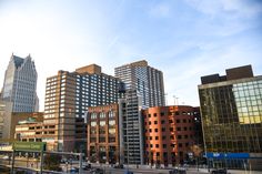 several tall buildings in the city with cars parked on the street