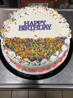 a birthday cake with sprinkles and the words happy birthday written on it