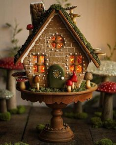 a gingerbread house on a pedestal with mushrooms around it and trees in the background