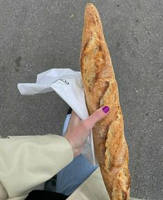 a person holding a long loaf of bread