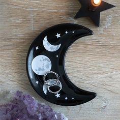 a black plate with rings on it sitting next to a star and moon shaped candle holder