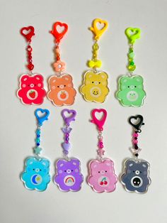 a bunch of key chains that are shaped like teddy bears with different colors and shapes