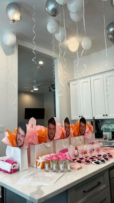 four men are sitting at a table with pink and white decorations in front of them