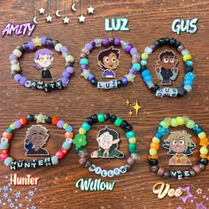 several bracelets with cartoon characters on them sitting on top of a wooden table next to stars