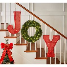 christmas decorations on the banisters and stairs with red ribbon tied around them for decoration