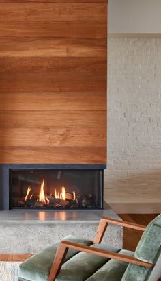 a living room with a fire place in the center and a chair next to it