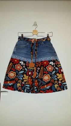 a women's jean skirt with floral print and tassels on the bottom