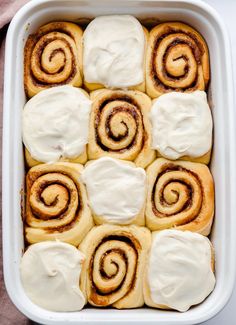 cinnamon rolls with cream cheese frosting in a casserole dish