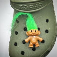 a green shoe with a small troll on it