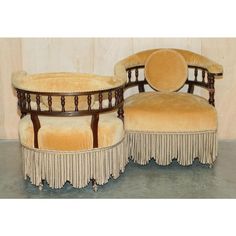 a pair of chairs and ottomans with fringe trim