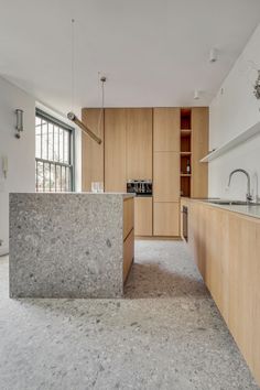 an empty kitchen with marble counter tops and wooden cabinets