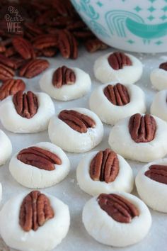 pecans are sitting on top of white cookies