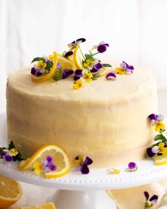 a cake with lemons and purple flowers on it