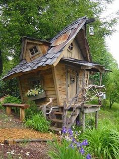 a small wooden house sitting on top of a lush green field