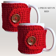 two coffee mugs with buttons on them sitting next to each other