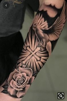 a man with a cross and rose tattoo on his arm