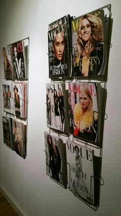 several magazines are hanging on the wall with magazine pages attached to it's sides