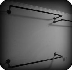 black and white photograph of two metal bars hanging on the side of a wall in a bathroom