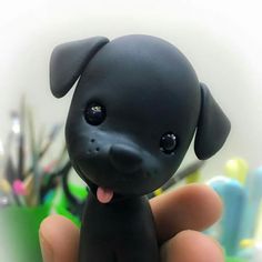 a small black dog toy sitting on top of a table