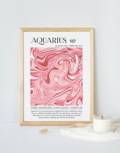 a pink and white poster hanging on the wall next to a candle