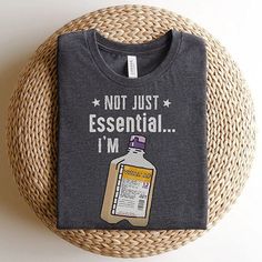 a t - shirt that says not just essential i'm with a bottle on it