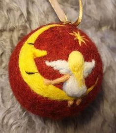 an ornament shaped like a christmas ball with a little angel on it's back