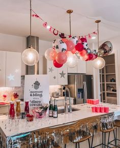 a kitchen filled with lots of balloons and wine glasses on top of a countertop