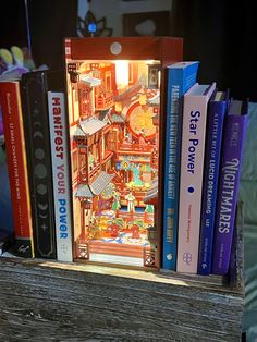 a book shelf with several books on top of it and a clock in the middle