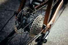 the front wheel of a bicycle with gears on it's spokes and chain