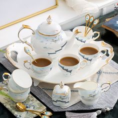 there is a tea set with cups and saucers on the table next to it