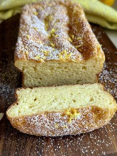 a loaf of lemon bread sitting on top of a wooden cutting board