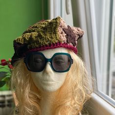 a mannequin wearing sunglasses and a crocheted hat