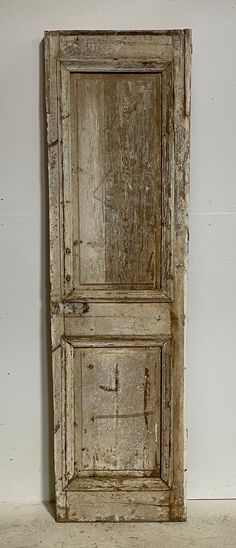 an old wooden door sitting on top of a white floor in front of a wall