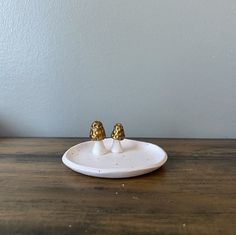 two little birds sitting on top of a white plate