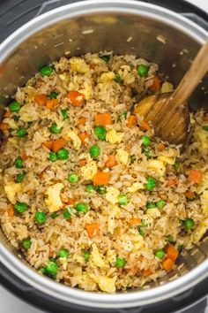 rice, peas and carrots are mixed together in an instant pot with a wooden spoon