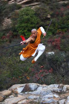 a man flying through the air while riding a skateboard on top of a rock