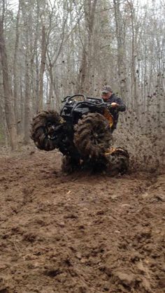 a person riding an atv in the mud