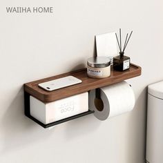 a wooden shelf with two rolls of toilet paper on it next to a white wall