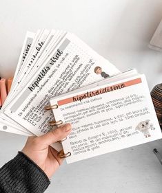 a person holding several papers in their hand