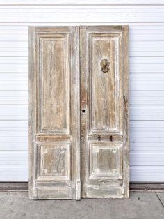 an old white double door on the side of a building