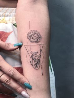 a woman's arm with a heart and brain tattoo on it