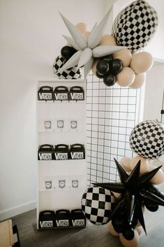 black and white balloons are hanging on the wall next to a sign that says vader