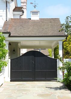 a black gate in front of a white house