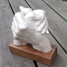 a white sculpture is sitting on a wooden stand