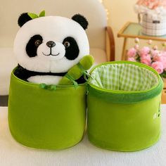 a stuffed panda bear sitting in a green basket