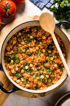 a pot filled with food next to tomatoes and parsley