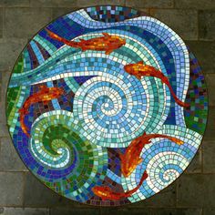 a round stained glass window with fish on it